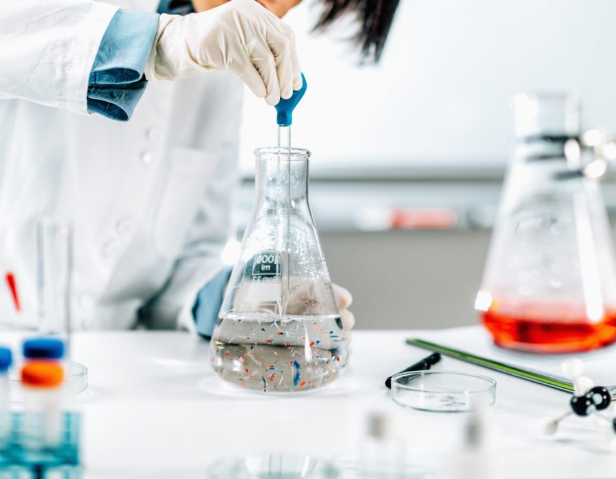 Microplastic pollution research. Water quality researcher taking water samples with a pipette, examining the quantity and type of microplastic contamination.